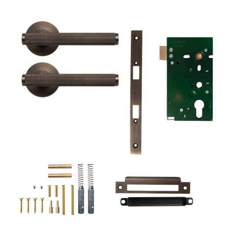 Door handle and lock mechanism set on a white background. BellevueSolidBrassKnurledMorticeLockPassageLeverSetInBronze