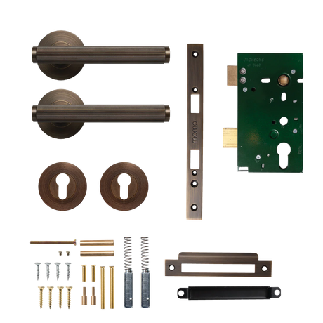 Door hardware kit with handles, lock mechanism, and accessories on a white background. BellevueSolidBrassLinedLeverEntranceSetInBronze