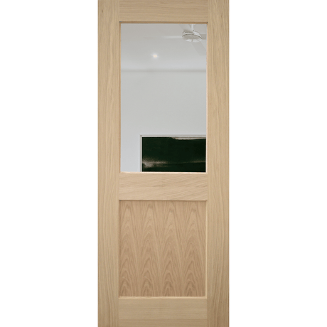 A light oak interior door with a rectangular glass window in the upper half and a recessed lower panel, shown against a plain white background.