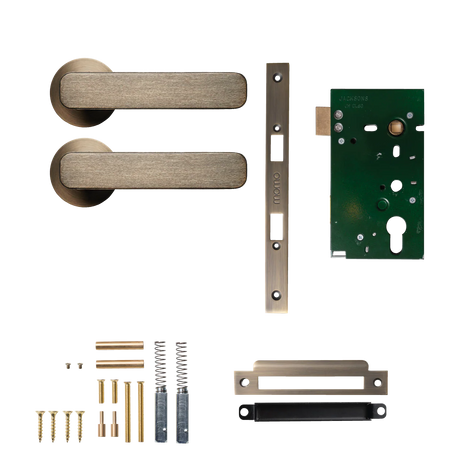 Door handle assembly with components on a white background. MomoAspenSolidBrassMorticeLockPassageLeverSetInDarkBrushedBrass