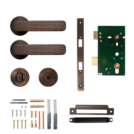 Door handle and lock assembly on a white background. MomoAspenSolidBrassMorticeLockPrivacyLeverSetInBronze