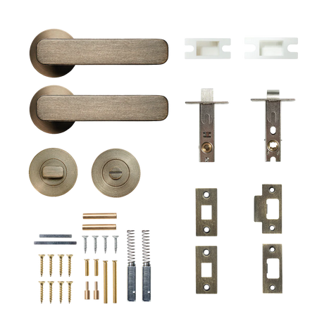 Door handle and lock mechanism set on a white background. MomoAspenSolidBrassTubularLatchPrivacyLeverSetInDarkBrushedBrass